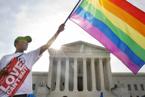 A protestor with a rainbow flag outside the Supreme Court